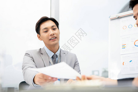 在办公室开会时向客户提出业务计划文件的亚洲大富善心生意人推荐图片