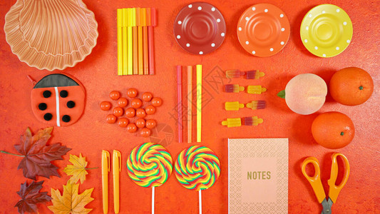 橙色美学回到学校主题创意布局平铺学校用品糖果和文具背景图片