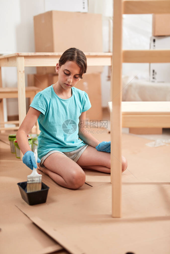 小女孩在新公寓中绘画和组装家具搬图片