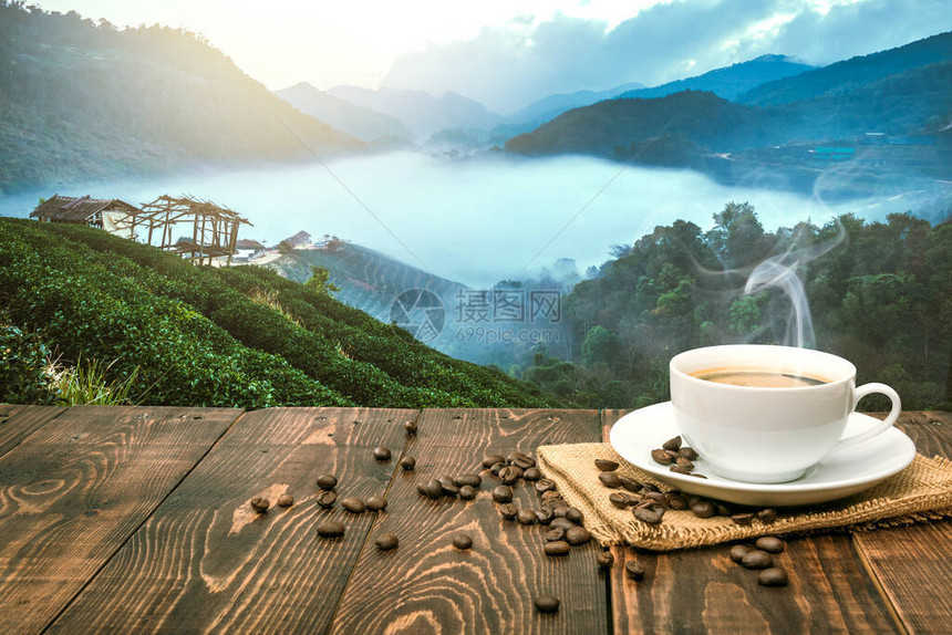 上午一杯咖啡和咖啡豆日出时有山地背景图片