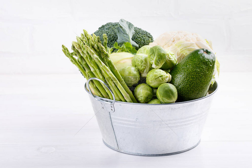 白色桌子上的分类绿色蔬菜西兰花椰菜球芽甘蓝大头菜鳄梨芦图片