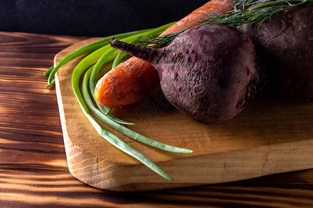 甜菜胡萝卜土豆木板上的绿洋葱煮蔬菜沙图片