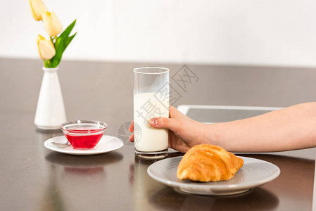 食着羊角面包糖浆和牛奶杯的桌子上男图片