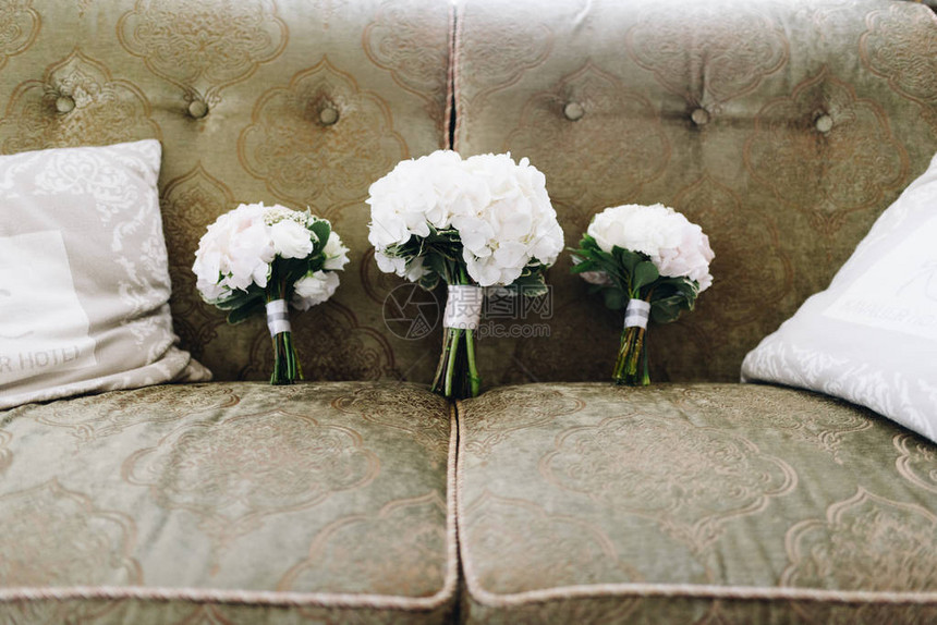 三个婚礼花束白色的海绵花朵站在枕头图片