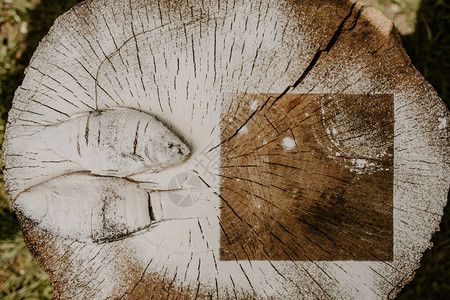 炸鱼鲫躺在一个破旧的木桩上的盘子上图片