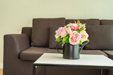 桌上花瓶与客厅区域的枕头和沙发装饰内部图片