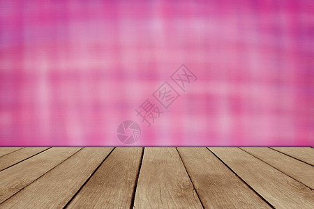 粉红色壁纸前的棕色木制桌面软模糊背景图片