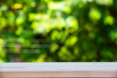空木制桌纹理绿色花园模糊的bokoh背景图片