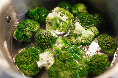 在锅里煮熟的新鲜青菜花椰菜沸水背景图片