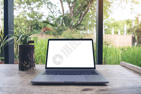自然背景的老式木桌上带有空白色桌面屏幕的笔记本图片
