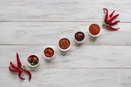 各种红辣椒产品都放在白木桌上在白色图片