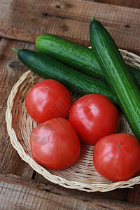 木桌上的新鲜黄瓜和西红柿图片