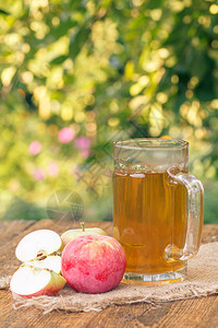 采摘的苹果和苹果酒放在木板上的玻璃高脚杯中图片