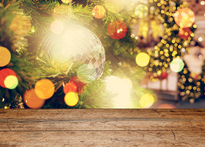 在圣诞节或新年快乐时间前的空旧木桌圣诞树与五颜六色的球假日产图片