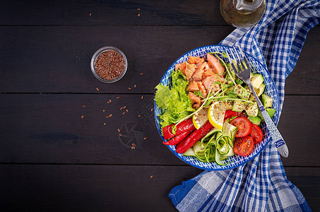 健康烤三文鱼鳄梨番茄黄瓜辣椒粉和奇亚籽蓝色碗中的均衡午餐碗图片