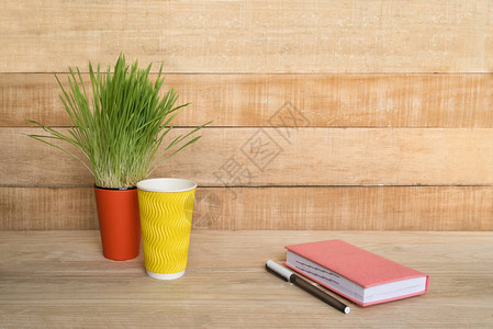 木制桌上的笔记纸和笔绿色家庭种植背景图片