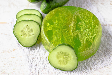 在白色背景的绿色黄瓜肥皂与黄瓜片用黄瓜肥皂进行水疗护图片