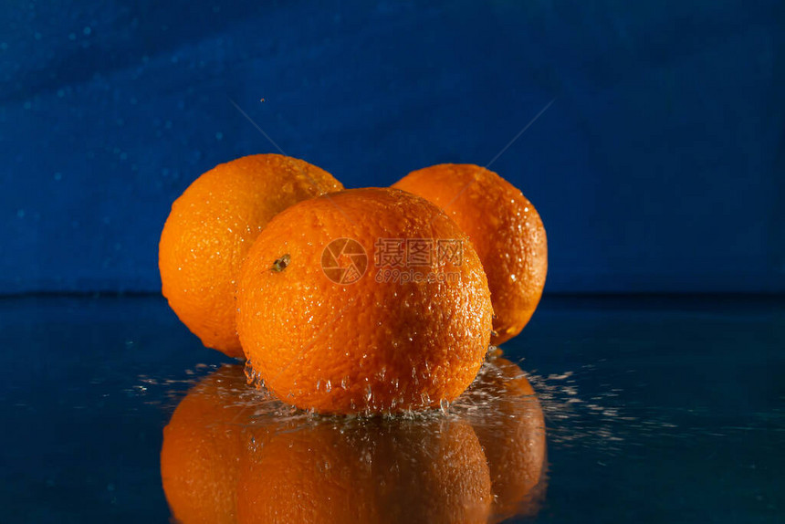 桌子上的新鲜橙子蓝色背景图片