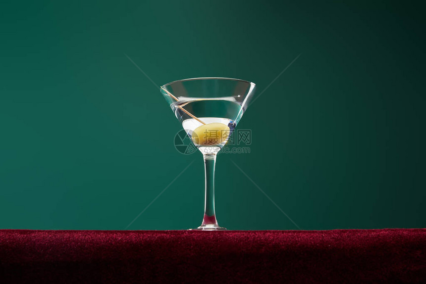低角玻璃鸡尾酒杯加苦茅斯和全橄榄在绿色图片