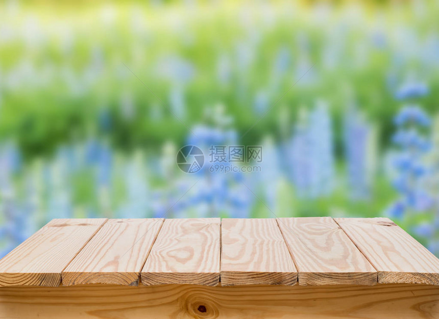 有迷离蓝色花背景的木桌图片