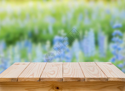 有迷离蓝色花背景的木桌图片