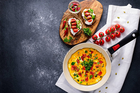 煎锅中的煎蛋卷配樱桃番茄和菠菜的健康早餐图片
