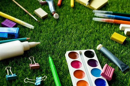 绘画学校用品彩色铅笔和草地上的塑胶图片