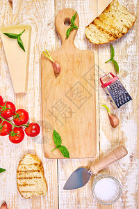 配有藤蔓西红柿罗勒帕尔马干酪橄榄油大蒜木制背景面包图片