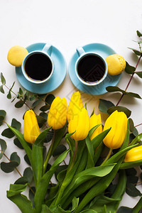 两杯蓝色咖啡黄郁金香放在一张旧桌子图片
