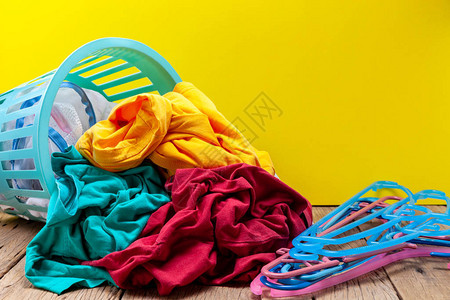 将脏洗的衣服放在木板黄色背景图片