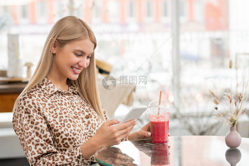 在咖啡厅坐在桌边喝着饮料时图片