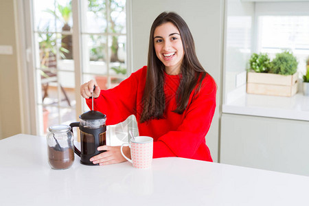 年轻美女在清晨咖啡上微笑准备一杯咖啡拿铁图片