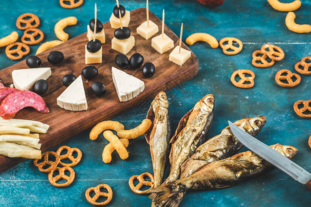 蓝桌上放着奶酪块橄榄和饼干的香肠图片