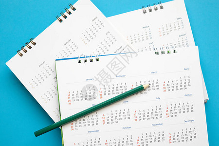 带铅笔的日历页在蓝色背景业务规划预约会背景图片