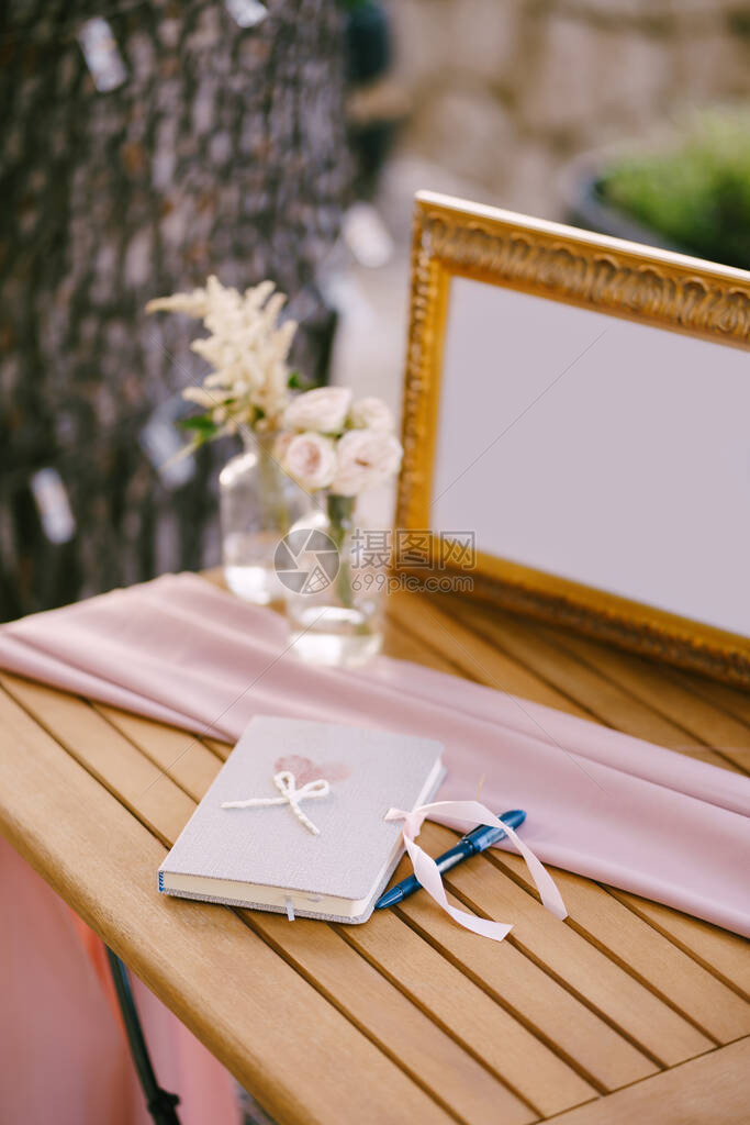 一张结婚愿望的笔记本蓝笔花瓶里的花朵还图片