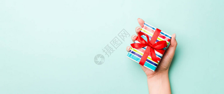 女人的手用彩色纸给包装好的圣诞节或其他节日手工礼物图片