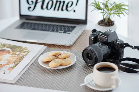 盘子里放着美味的自制饼干一杯咖啡和相册图片