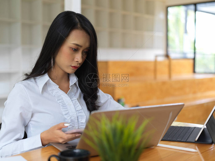 女职工在共同工作空间用笔记本电脑专心图片