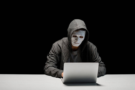 网络巨魔在黑线上孤立的笔记本电脑键盘上打字面具时使用的匿背景