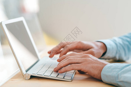 年轻网站设计师在办公室工作场所触摸板前工作时触摸键盘图片