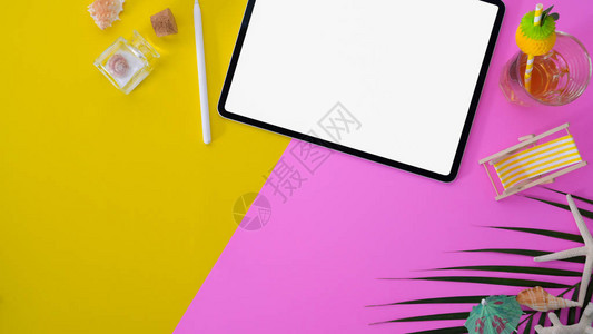 含有粉色和黄色桌边白屏幕平板和办公用品的彩色夏季工作图片