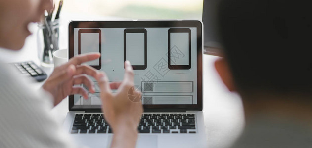 专业UX图形设计师团队在现代办公室一起使用智能手图片