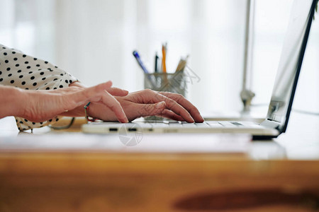 女创业者在办公室办公桌用笔记本电脑工作的手图片