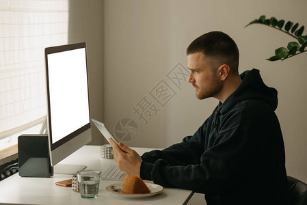 远程在线工作程序员使用一体机远程工作一位同事在家中拿着背景图片
