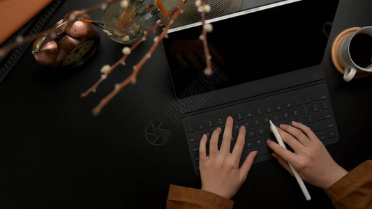 黑奢华办公桌带有装饰的数码平板电脑键盘上打字的妇女图片