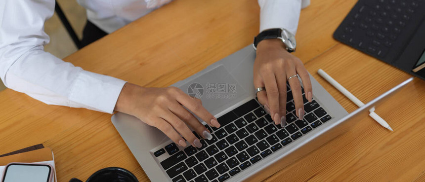 用手提电脑键盘打字在办公室的木图片