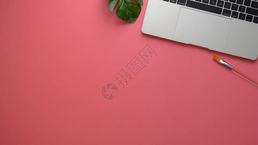 带有电脑笔记本电脑装饰和粉红桌背景复制空间的时尚工作图片
