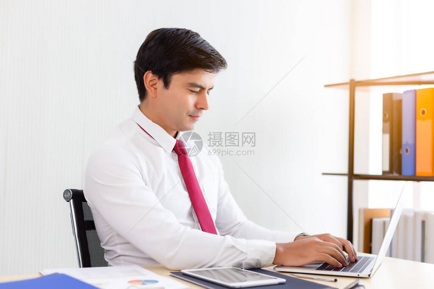 年轻员工在公司办公室度假期间在笔记本电脑上工作在笔记本电脑上为项目工作的商人聪明的人需要加班才能完成订单在图片