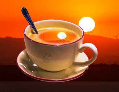 清晨咖啡加勺子和橙色日落的图片