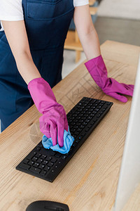 清洁服务工作人员用布放在桌上的打扫计算机的图片